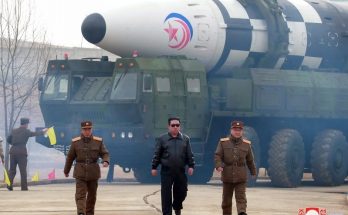 North Korean Supreme Leader, Kim Jong Un walking infront of Ballistic Missile.