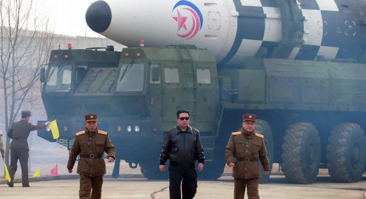 North Korean Supreme Leader, Kim Jong Un walking infront of Ballistic Missile.